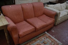 A three seat sofa in coral pink upholstery.180cm wide Best Bid