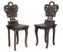 A pair of 'Black Forest' carved and stained wood children's chairs, early 20th century, with foliate