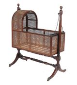 A Regency mahogany cradle on stand,   circa 1800, with hooded caned cradle supported on turned