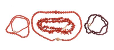 A coral bead necklace, composed of graduating circular shaped coral beads, to a reeded circular