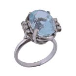 An aquamarine and diamond ring, the central oval shaped aquamarine claw set between brilliant cut