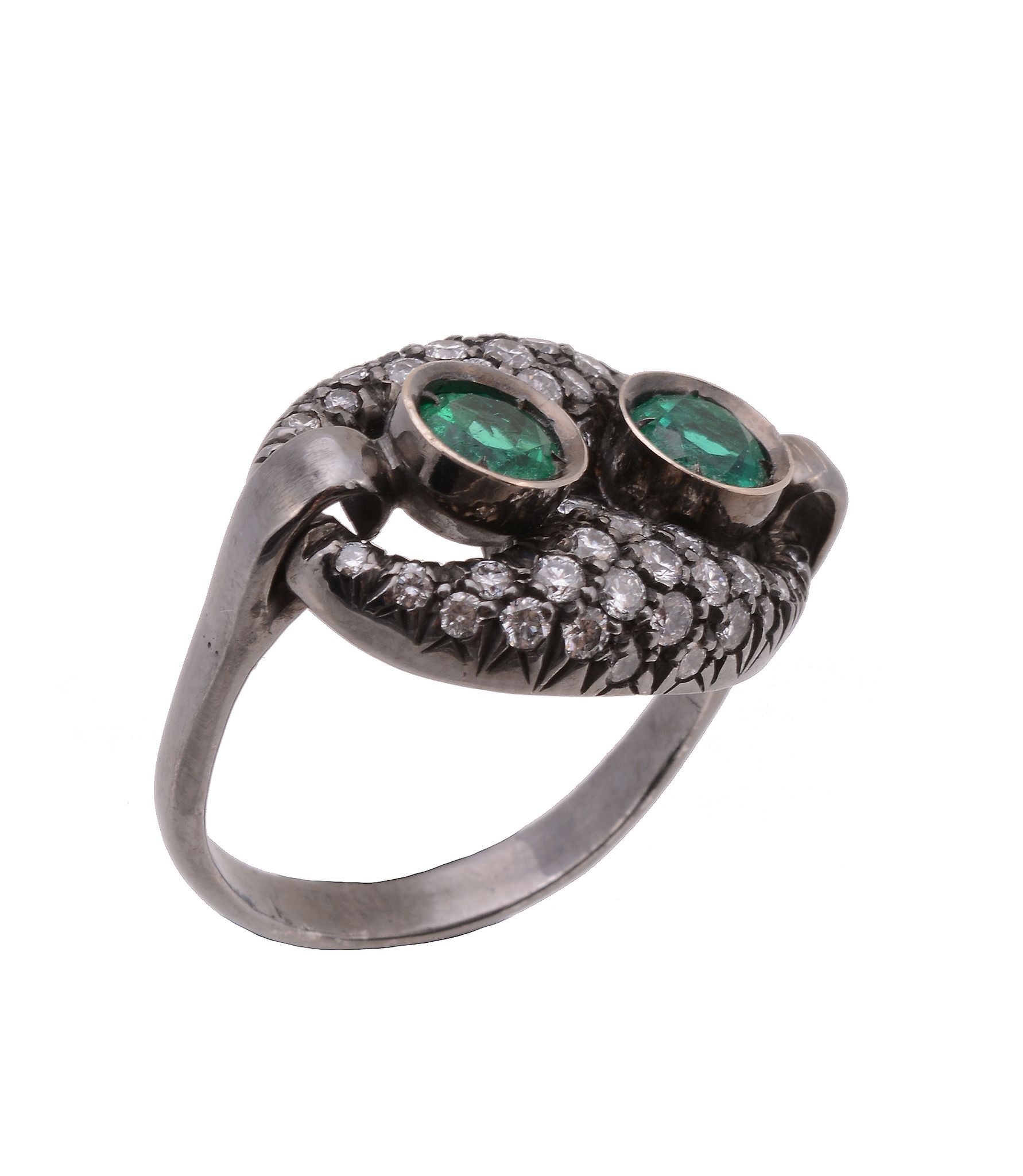 An emerald and diamond ring, the two circular shaped emeralds within a surround of brilliant cut