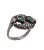 An emerald and diamond ring, the two circular shaped emeralds within a surround of brilliant cut