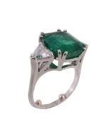 An emerald and diamond ring, the rectangular shaped emerald, weighing 7.82 carats, claw set