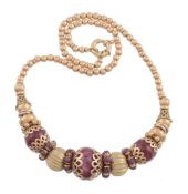 A ruby bead necklace, the central polished ruby bead in a pierced scallop setting between further