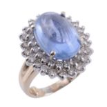 A sapphire and diamond ring, the oval shaped cabochon Burmese sapphire, stated to weigh 12.36