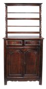 A French oak bookcase cabinet, 18th century and later, the moulded cornice with two shelves above
