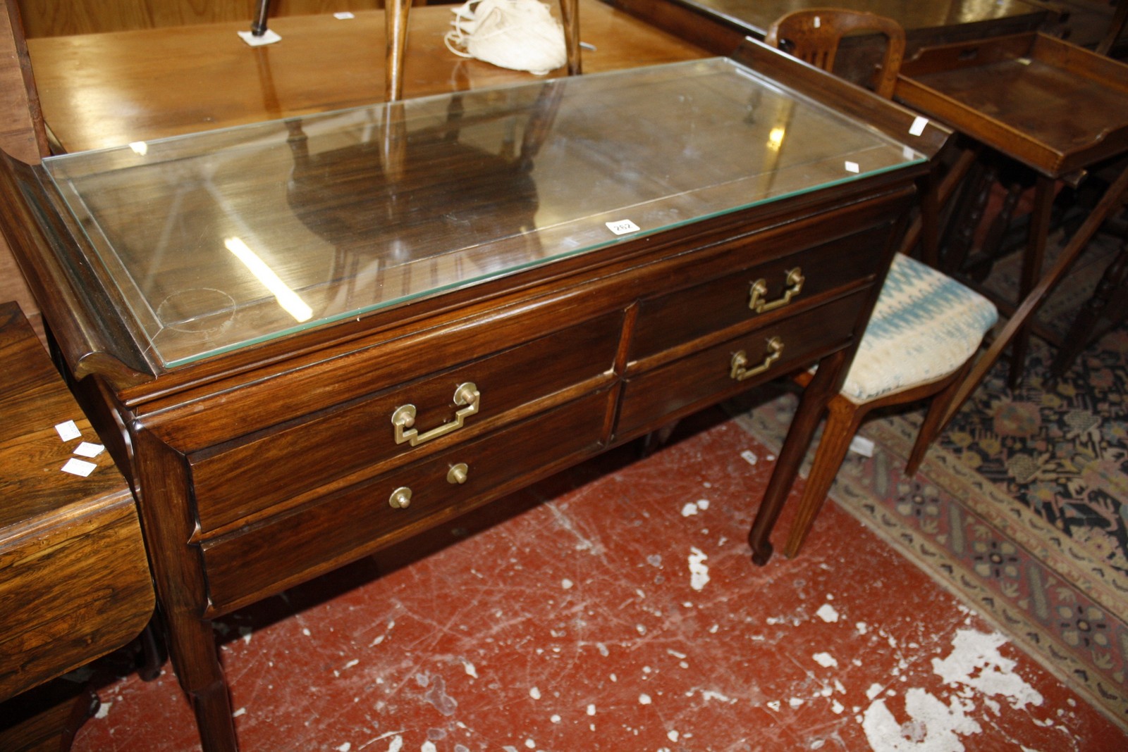 A Chinese hardwood side table with four frieze drawers 117cm wide, a Chinese hardwood dining table