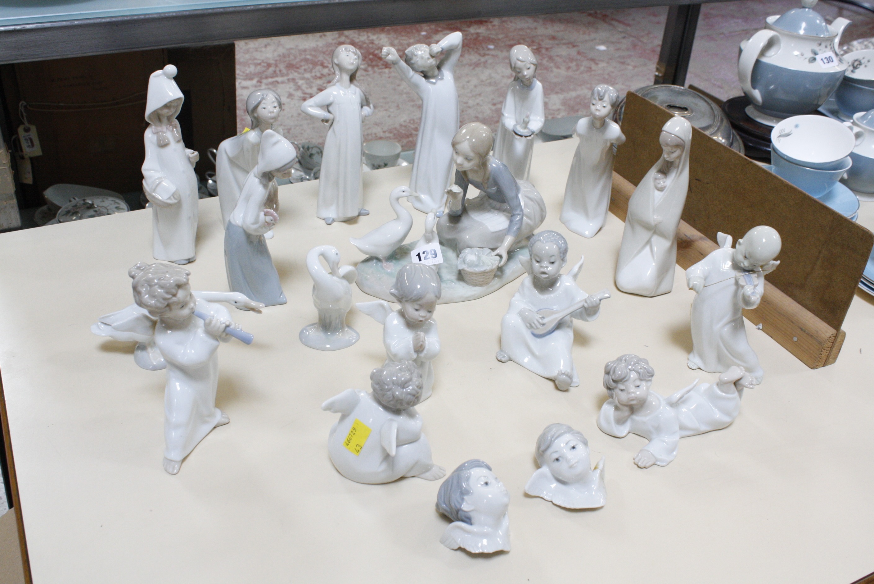 A selection of Lladro figurines, to include cherub musicians, girl with geese and sleepy children (