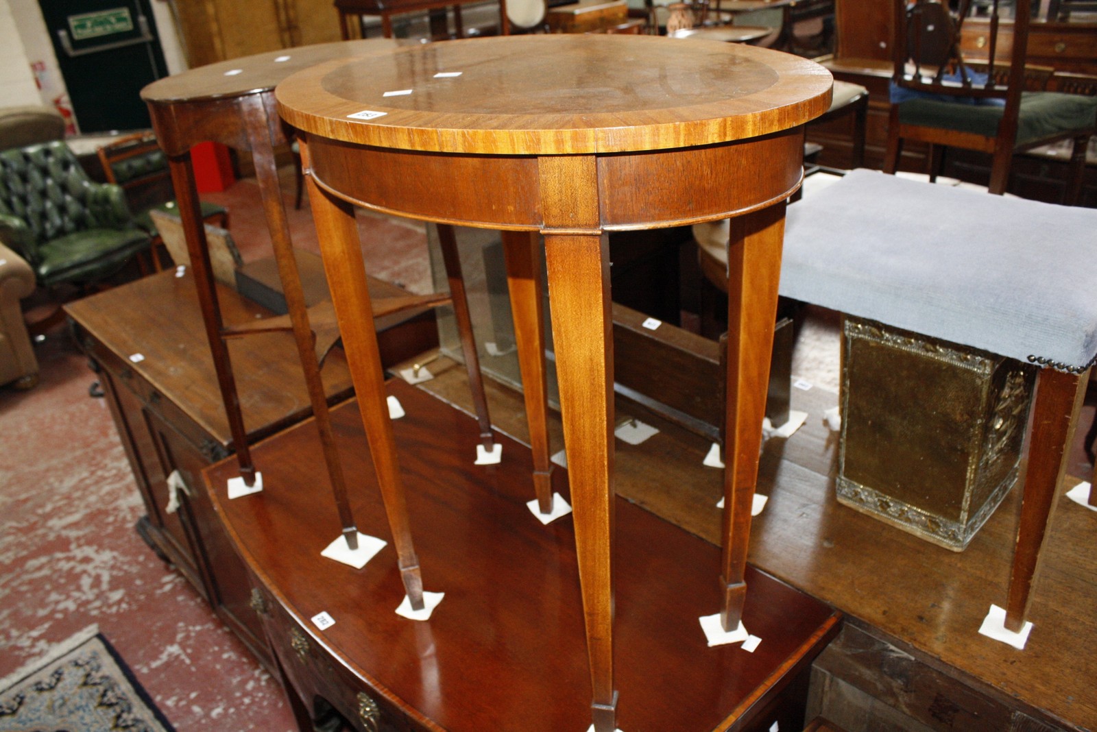 An oval crossbanded occasional table with square tapering legs and spade feet, together with another