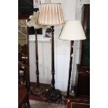 Three mahogany standard lamps, each with turned stems and circular moulded bases (sold as parts) £