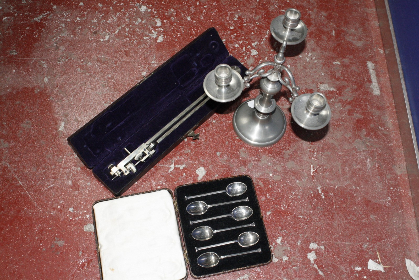 A cased set of six silver spoons, pewter candlesticks and a cased precision engineering instrument