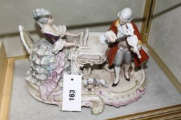 A Continental 18th century style porcelain group of a girl playing piano accompanied by a man on