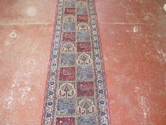 A Persian runner with red field stylised animals £120-150