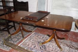 A Regency style mahogany twin pedestal dining table with two additional leaves.247cm fully