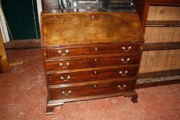 A George III mahogany bureau, the sloping fall enclosing an arrangement of drawers and pigeon holes,