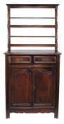 A French oak bookcase cabinet, 18th century and later, the moulded cornice with two shelves above