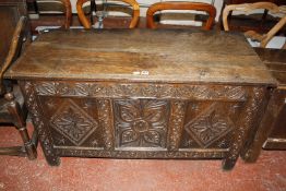 A late 17th Century oak coffer, with a hinged lid, the central panel with stylized floral decoration