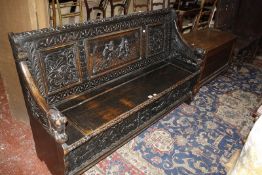 A 19th Century carved oak hall seat, the central panel depicting a tavern scene, with a hinged lid