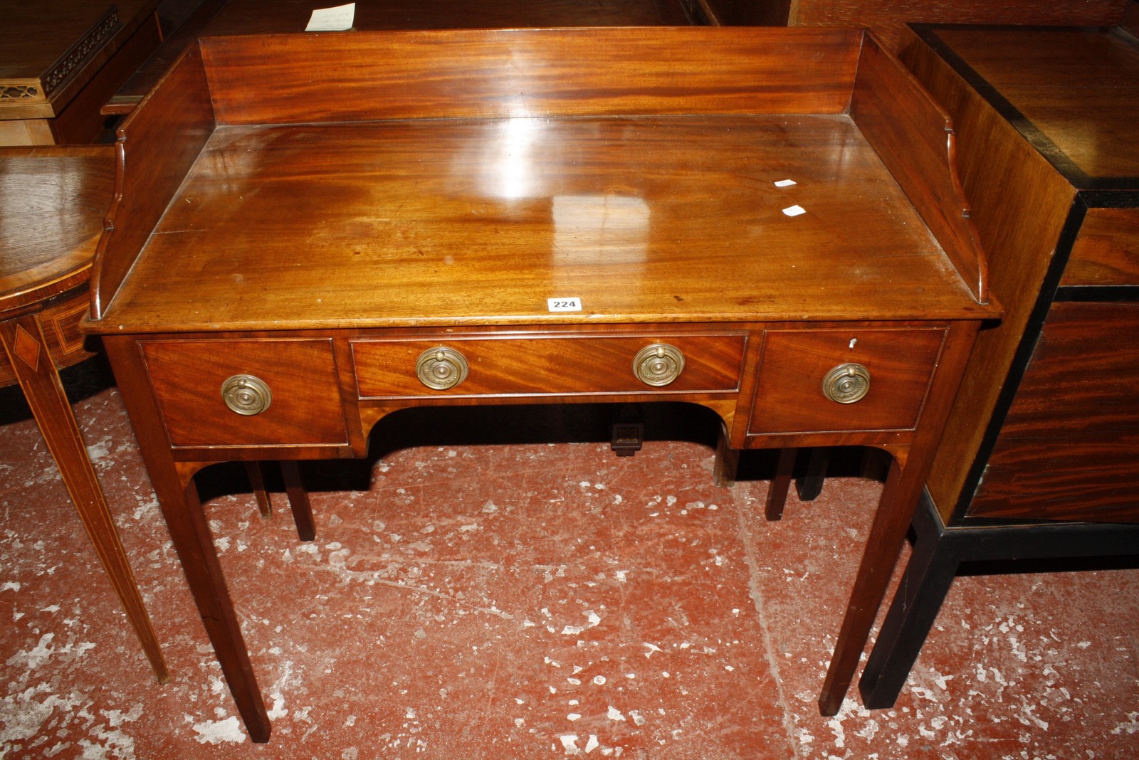 An early 19th Century mahogany kneehole side table, with three quarter gallery, three short