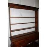 A stained hardwood dresser, with a platerack and three frieze drawers to the lower section 155cm