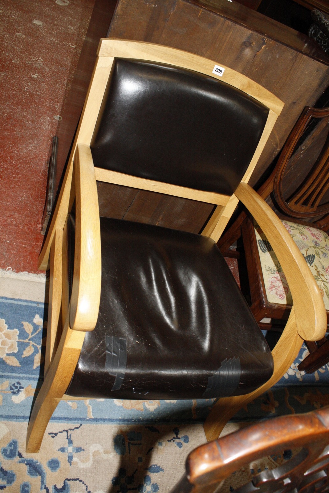 An oak and leather open armchair