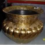 A hammered brass log bin, gadrooning and foliate decoration, 40cm high and 47.5cm in diameter