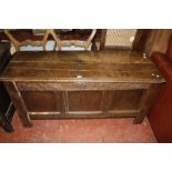 A 17th Century oak coffer, with a hinged lid, carved frieze and triple panel front on stile feet