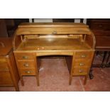 An early 20th Century oak roll top desk, with tambour front and six short drawers on square