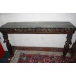 An oak carved console with simulated green marble top, trailing foliage frieze, supported on