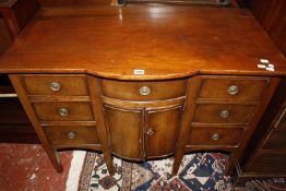 An early 19th Century mahogany sideboard with bowfront central section flanked by short drawers