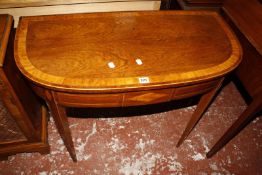 A George III mahogany and satinwood crossbanded card table, with D-shaped top and inlaid frieze on