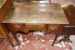 A George III oak lowboy with three frieze drawers and shaped apron on turned legs and pad feet