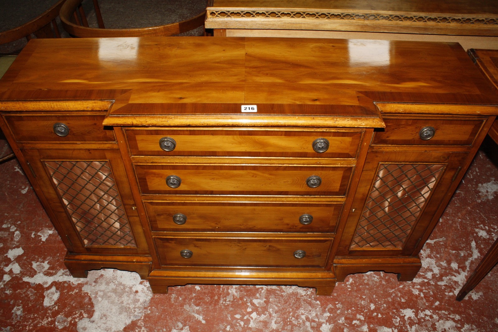 A Georgian style yewwood breakfront side cabinet, the central cupboard flanked by short drawers