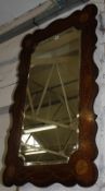 A shaped rectangular painted mahogany wall mirror, decorated with small flowers, 121cm high, 75cm