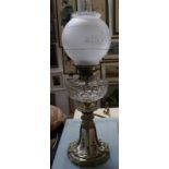 A glass oil lamp, with brass and ceramic shaped base, 65cm high approx.