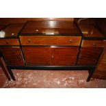 A Heals ebonised and mahogany sideboard, with a stepped top, three short drawers and cupboards below