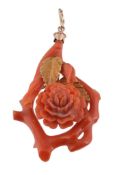 A coral pendant, carved as a flower head with textured gold coloured leaves  A coral pendant,
