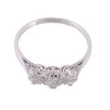 A three stone diamond ring, set with three brilliant cut diamonds in claw...  A three stone