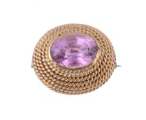 A pink topaz brooch, the oval shaped pink topaz collet set within a...  A pink topaz brooch,   the