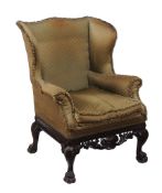 A mahogany wing armchair in George II style, 19th century, the back, wings  A mahogany wing armchair