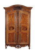 A Louis XV walnut armoire, circa 1750, the pair of multi panelled cupboard...  A Louis XV walnut