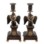 A pair of Empire patinated and parcel gilt bronze candlesticks  A pair of Empire patinated and