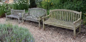 A pair of teak garden benches, with arched and slatted back and seat A pair of teak garden
