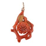 A coral pendant, carved as a flower head with textured gold coloured leaves  A coral pendant,