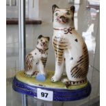 A pair of Staffordshire cats, on blue plinth bases, 18cm high (2)