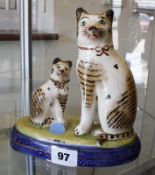 A pair of Staffordshire cats, on blue plinth bases, 18cm high (2)