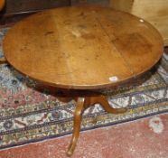 A19th century oak tilt top table on a pedestal tripod base.92cm diam