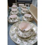 A Royal Worcester part tea service, decorated with a border of pink roses within gilt C-scroll and