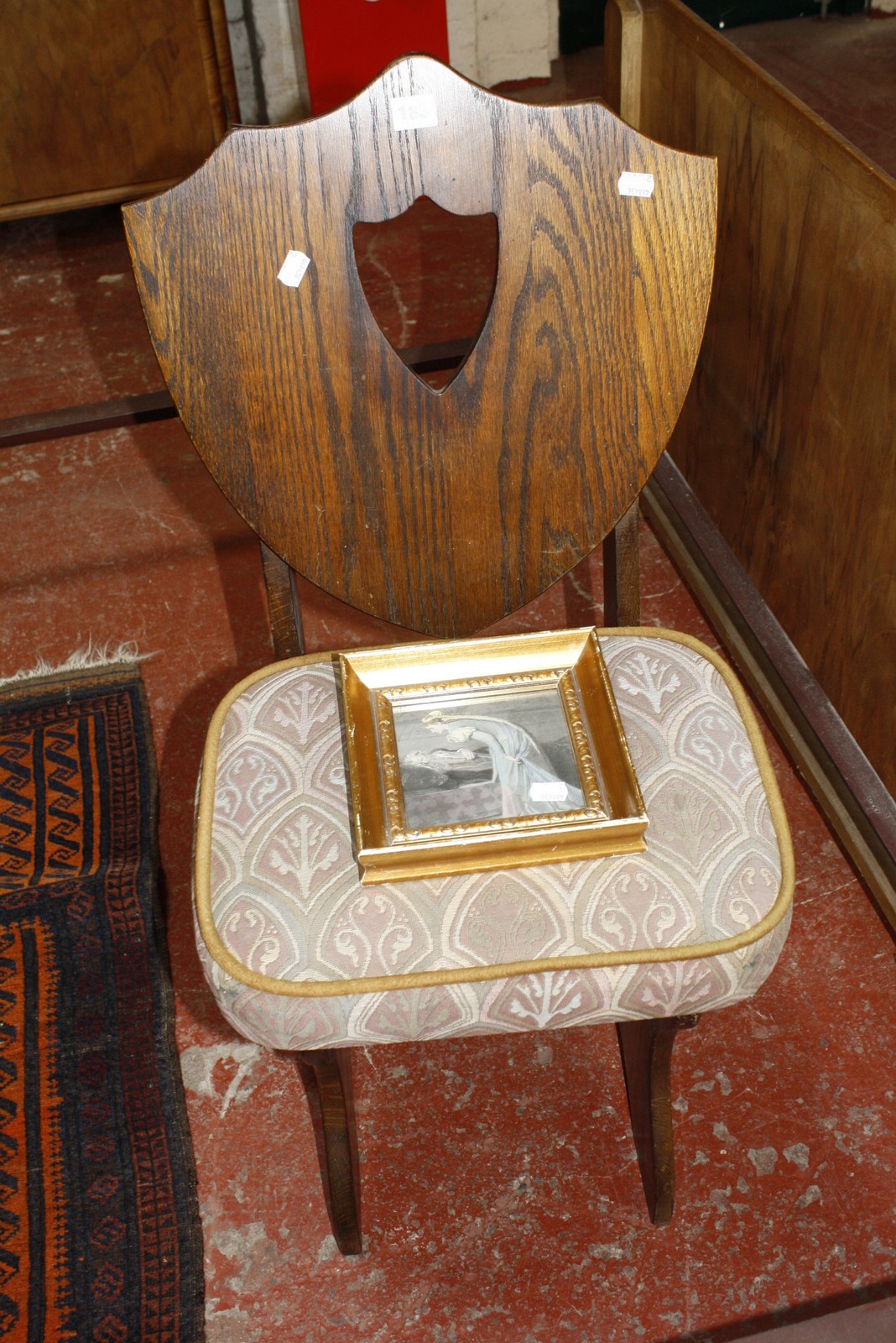 A Gothic style shield back chair, a prayer mat and a hand coloured engraving.
